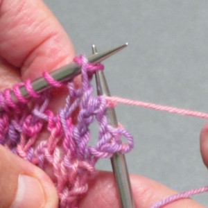 Grab second stitch with right-hand needle point and pull it through the first stitch.